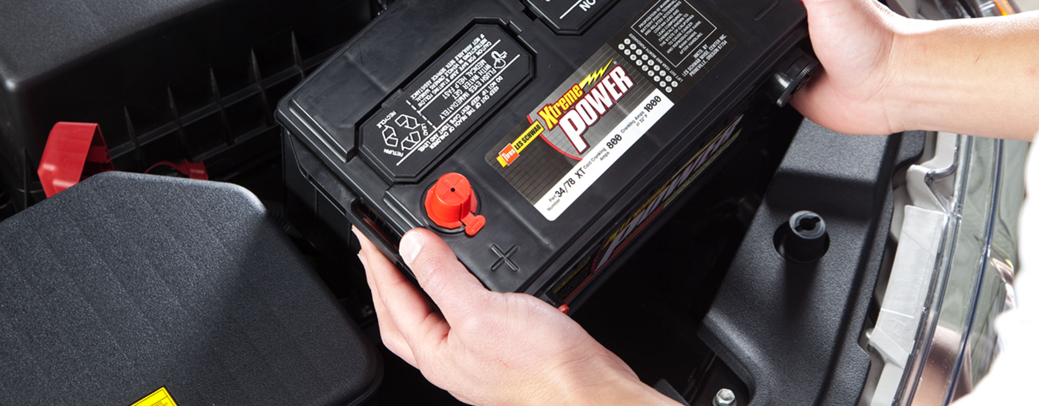 A close up of a technician installing a new car battery.