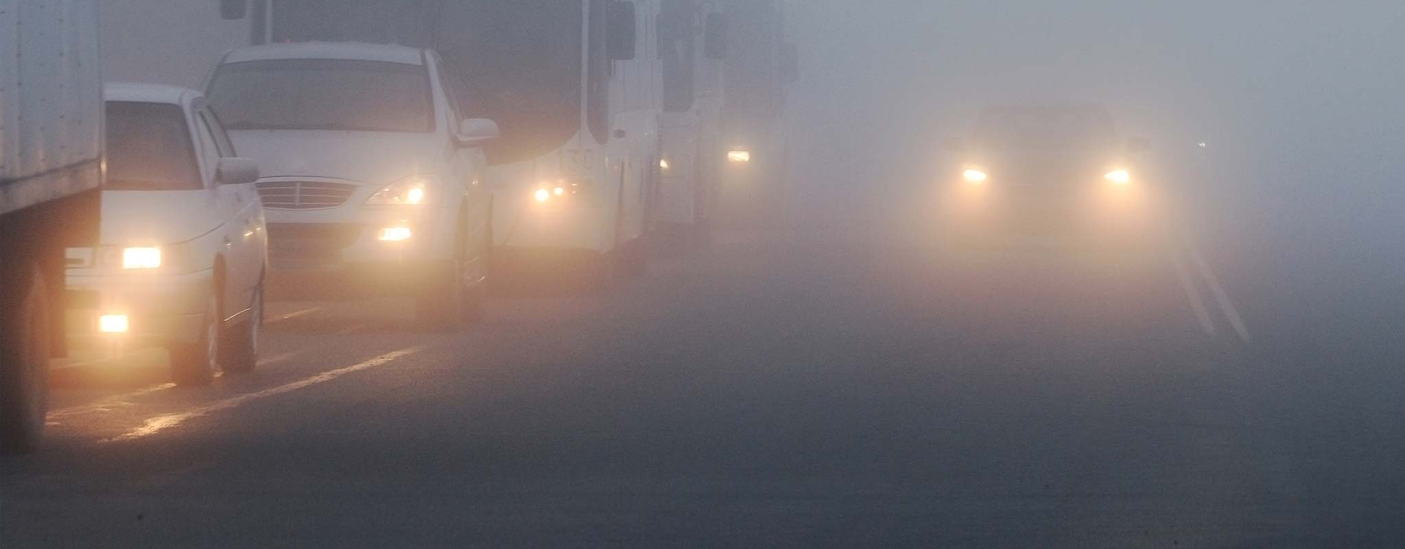 Vehicles on a foggy highway.