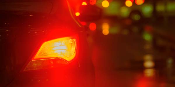 Illuminated car brake light at night.