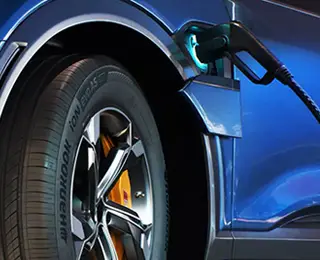 A blue electric vehicle charging at night.