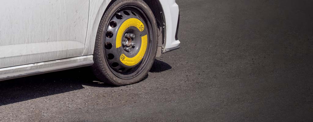 White car with donut spare installed.