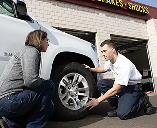 Les Schwab employee talking with a customer about their tire