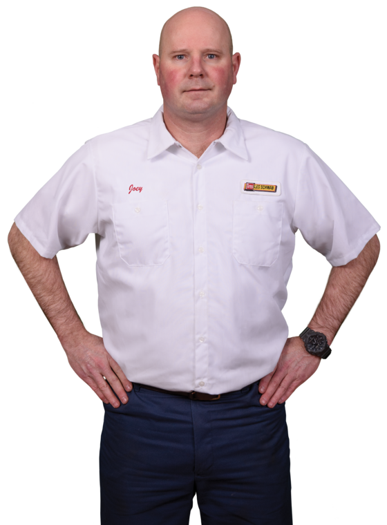 A Les Schwab technician stands arms akimbo. His name is Joey